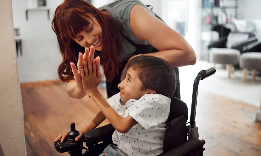 Hairdresser, high five and child in hair salon happy with hair cut or hairstyle. Disabled kid in wh