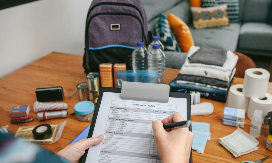 Woman doing checklist of emergency backpack